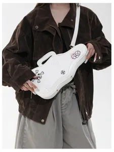 Modèle portant un sac blanc en forme de guitare, avec motifs brodés et bandoulière réglable