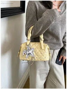 Borsa giallo chiaro al braccio, con trapuntatura a rombi, strass e ciondolo a stella argentato