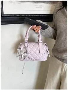 Una persona tiene una borsa lilla chiaro trapuntata, con strass e un ciondolo a stella argentato