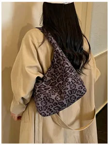 Vista posteriore della modella con motivo leopardato grigio-viola, tracolla beige e trench chiaro