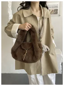 A brown plush bag shown in hand and crossbody, with a soft rounded shape and gold-tone hardware