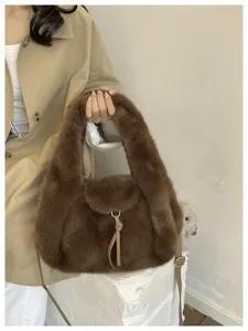 Close-up of a brown plush shoulder bag with a leather pull, metal buckle and detachable strap