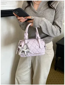 Borsa trapuntata lilla chiaro con strass e ciondolo a stella argentato, portata a mano