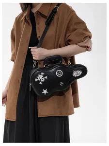 Sac guitare noir porté en bandoulière, brodé de crânes, fleurs et étoiles, avec détails métalliques