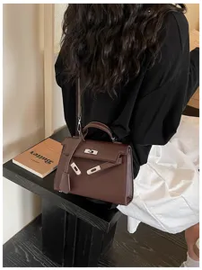 Dettaglio di una borsa marrone effetto pelle martellata, con chiusura argentata e tracolla amovibile
