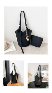 Bolso bombonera negro con textura, estuche a juego, correa ajustable y colgante decorativo