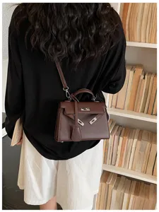 Vista da dietro di una modella con borsa marrone goffrata, chiusura argentata e tracolla sottile
