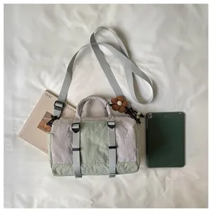 Borsa in nylon bicolore con tracolla removibile, fibbie grigie e ciondolo a fiore in legno
