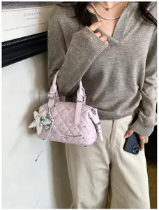 Borsa trapuntata color lavanda indossata, con dettagli scintillanti e ciondolo a stella argentato