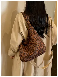 Vista da dietro di una persona con una morbida borsa marrone leopardata e un’ampia tracolla