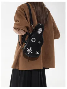 Vista da dietro di una modella con borsa nera a forma di chitarra, motivi ricamati e tracolla