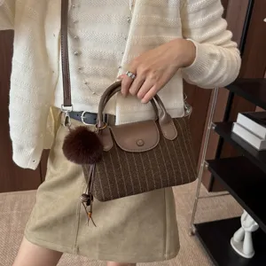 Borsa da donna in tessuto a righe, con patta e manici in pelle e un morbido ciondolo
