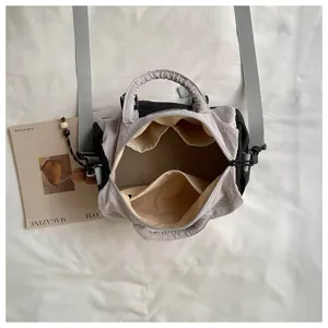 Vista dall’alto di una borsa grigia aperta, con fodera beige e numerose tasche interne
