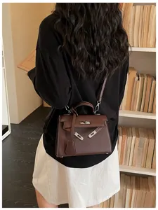 Vista posteriore di una modella con borsa marrone testurizzata, chiusura metallica e tracolla