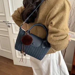 Borsa a sacca leggera blu scuro a righe, con manici e tracolla, indossata a bandoliera