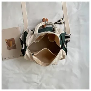 Vista dall’alto della borsa aperta, con fodera beige, tasche interne e ampia tracolla