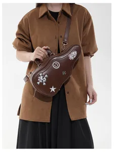 Modella con borsa marrone a forma di chitarra, decorata con ricami e tracolla regolabile