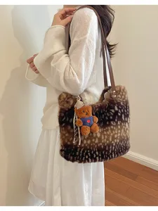 Model trägt eine braun gefleckte Kunstfelltasche mit Teddybär-Anhänger und braunen Schulterriemen