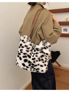 Rückansicht einer Person mit weißer Plüschtasche, schwarzen Flecken und braunen Schulterriemen