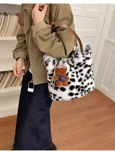 Seitenansicht einer Person mit gefleckter Kunstfelltasche, braunen Riemen und Teddybär-Anhänger
