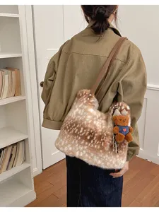 Getupfte Kunstfelltasche über der Schulter, mit braunem Riemen und kleinem Teddybär-Anhänger