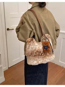 Getragene Kunstfelltasche mit braunem Fleckenmuster, langem Riemen und kleinem Teddybären-Anhänger