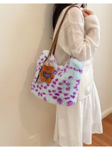 Plüschtasche mit hellblauen und violetten Flecken, braunem Schulterriemen und Teddyanhänger