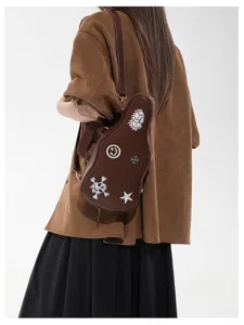 Vue arrière d’un sac guitare brun, avec patchs brodés de crâne, étoile et fleurs