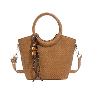 Sac seau brun à effet tressé, anse ronde, bandoulière réglable et breloque en perles de bois