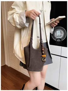 Bolso marrón con relieve de cocodrilo, al costado con correa ajustable y cuentas de madera decorativas