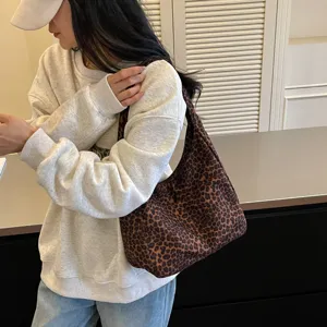Capiente shopper da donna con stampa leopardata marrone, indossata a spalla in una vista naturale.