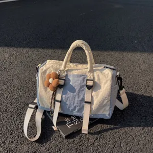 Borsa tote in nylon color avorio e azzurro chiaro, vista di lato con tracolla regolabile