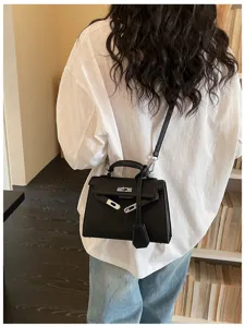 Vista posteriore di una persona con borsa nera, manico superiore e tracolla regolabile