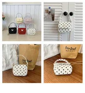 View of a small polka-dot bag with a bow, chain strap, and several color options on display.