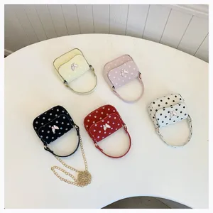 Overhead view of five small polka-dot bags with butterfly accents arranged on a white round table