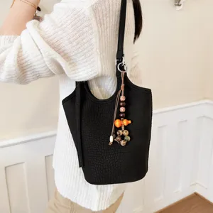 Bolso de cubo negro con relieve de cocodrilo, correa larga y colgante decorativo de cuentas de madera