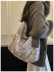 Vista laterale di una donna con capiente borsa marrone, fiori color crema e manici marrone scuro