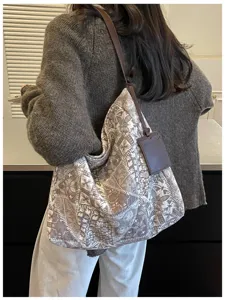 Borsa capiente taupe a fantasia indossata a spalla, con tracolla e targhetta in pelle marrone scuro