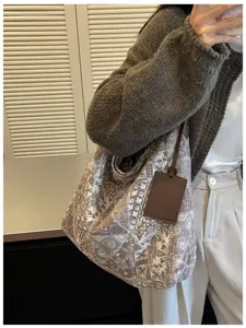 Donna con borsa morbida in tela, stampa botanica vintage e targhetta in pelle marrone scuro
