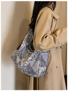 Vista laterale di una donna con una borsa in tessuto a motivi blu e bianchi e tracolla marrone