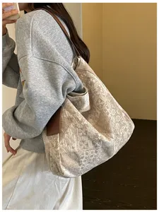 Vista laterale di una donna con una capiente borsa tote jacquard beige e manici in pelle marrone