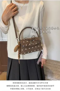 Borsa marrone a pois bianchi, patta con fiocco e nappa intrecciata su maglia e gonna plissé