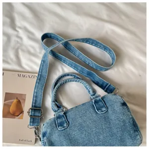 Détail du denim bleu clair délavé, avec poignées, bandoulière et boucles argentées