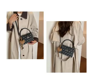 Due viste indossate di una mini borsa scura a pois bianchi, con ciondolo a cuore e tracolla