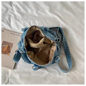 Vue de dessus d’un sac en denim ouvert, avec doublure beige, fermeture zippée et bandoulière