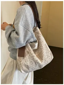 Vista laterale di una donna con tote jacquard color crema e manici marroni in stile casual