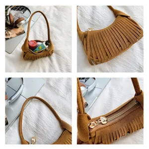 Close-up views of the brown suede-like bag’s fringe trim, curved shape, zipper and gold hardware