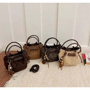 Quatre sacs seau à texture effet daim, bruns, camel, léopard et beige, présentés côte à côte
