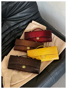 Vier clutches met krokodillenprint in bordeaux, bruin, geel en donkerbruin, met gouden sluitingen