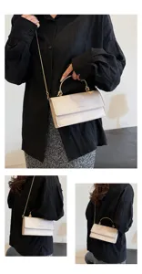Drieluik met een model dat een witte kleptas met gouden ketting in de hand en crossbody draagt.